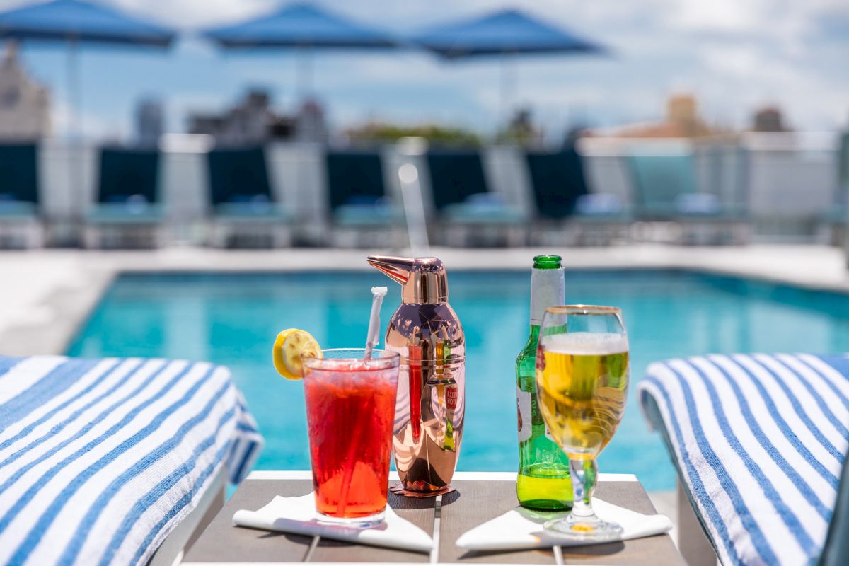 A table with drinks and towels by the pool