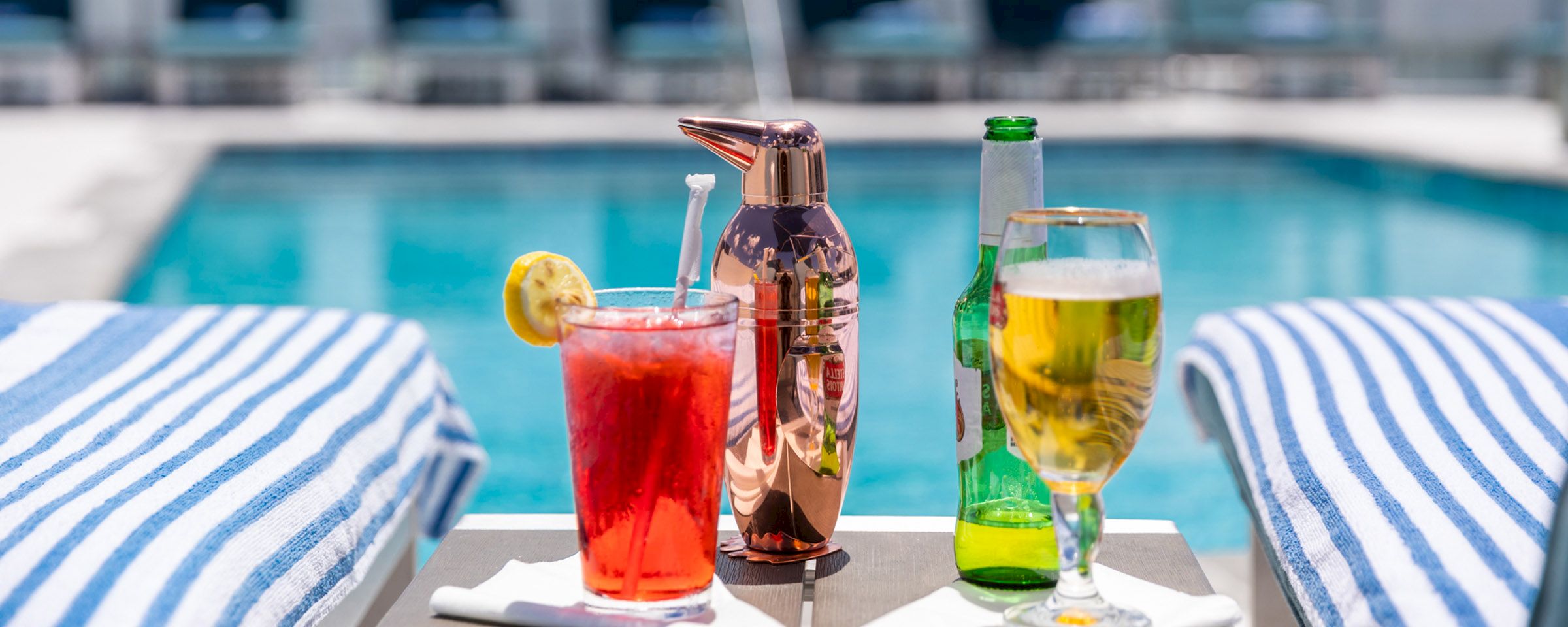 a poolside bar setup with drinks and towels