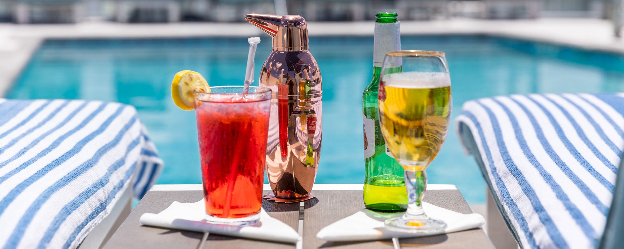 A table with drinks and towels by the pool