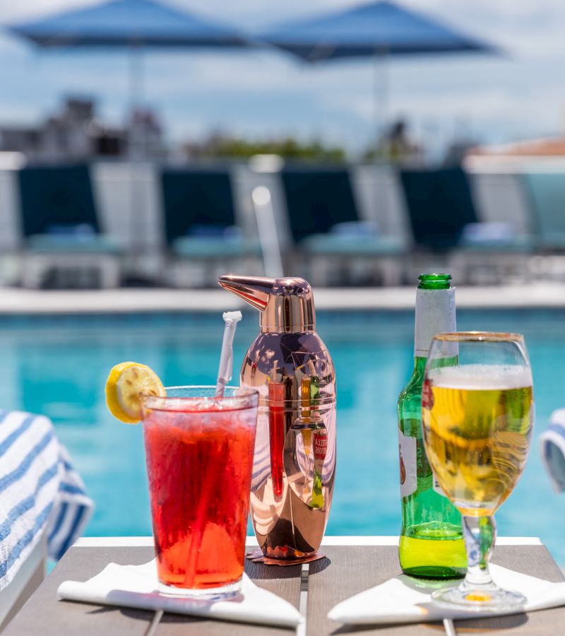 A poolside bar setup with drinks and towels.